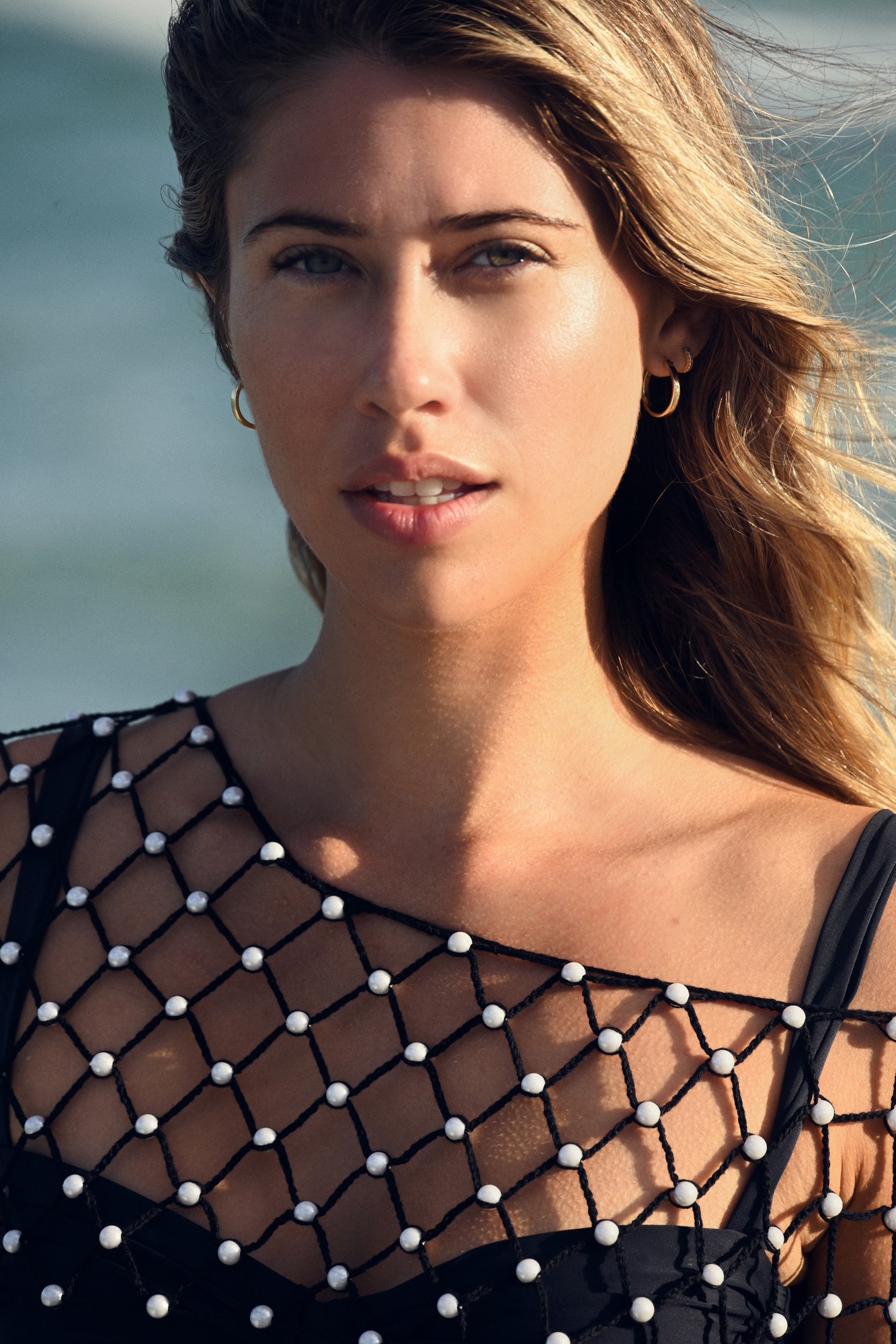 Portrait close-up, beaded net, gold hoops, ocean
