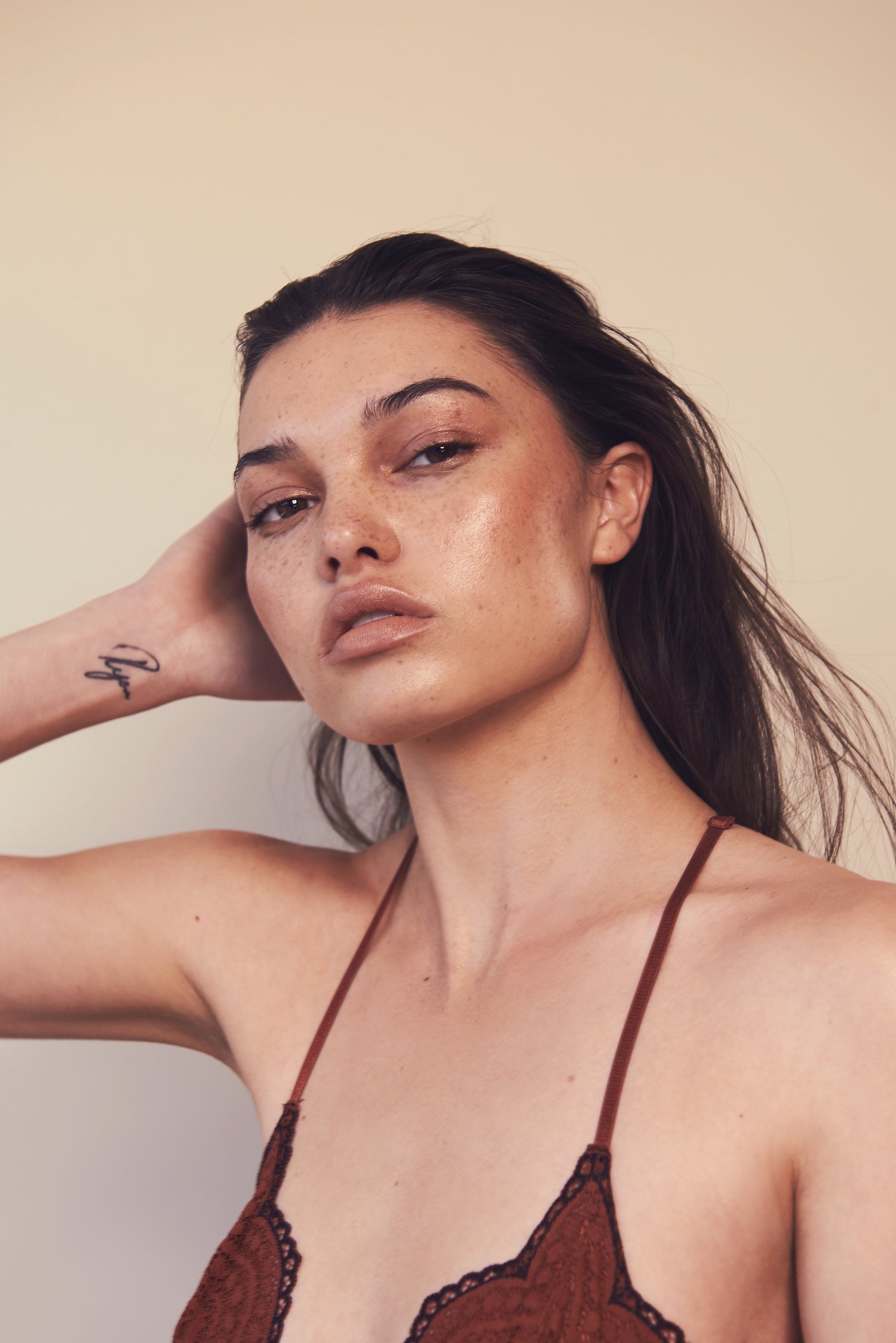 Bri, freckled beauty portrait, burgundy lace, wet hair, wrist tattoo, warm studio light