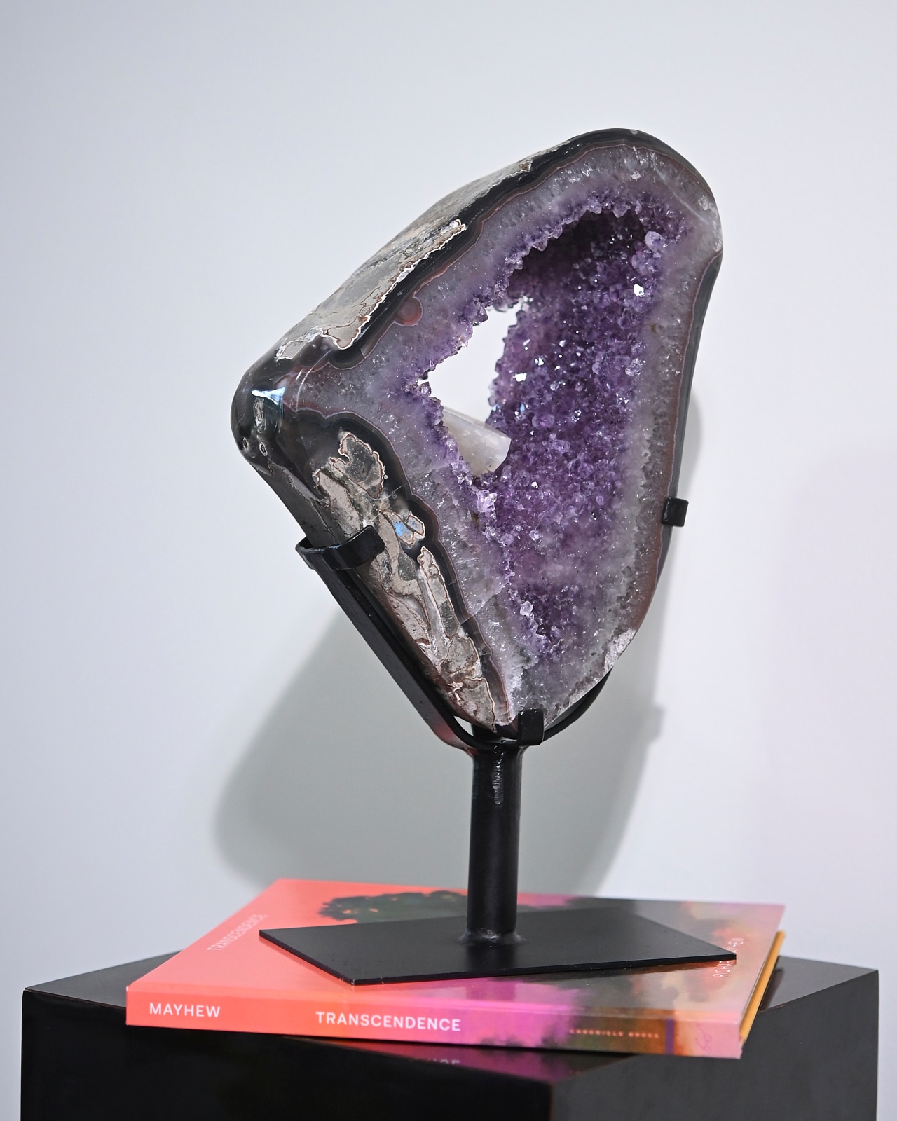 Amethyst geode on iron stand, Mayhew Transcendence book