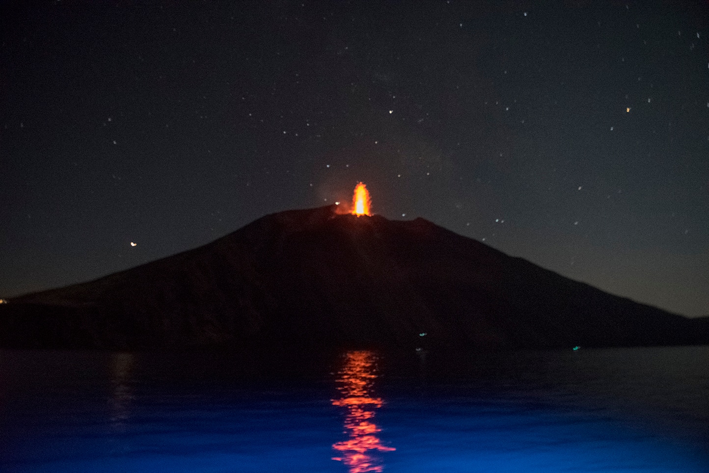 Stromboli eruption at night, lava against dark sky