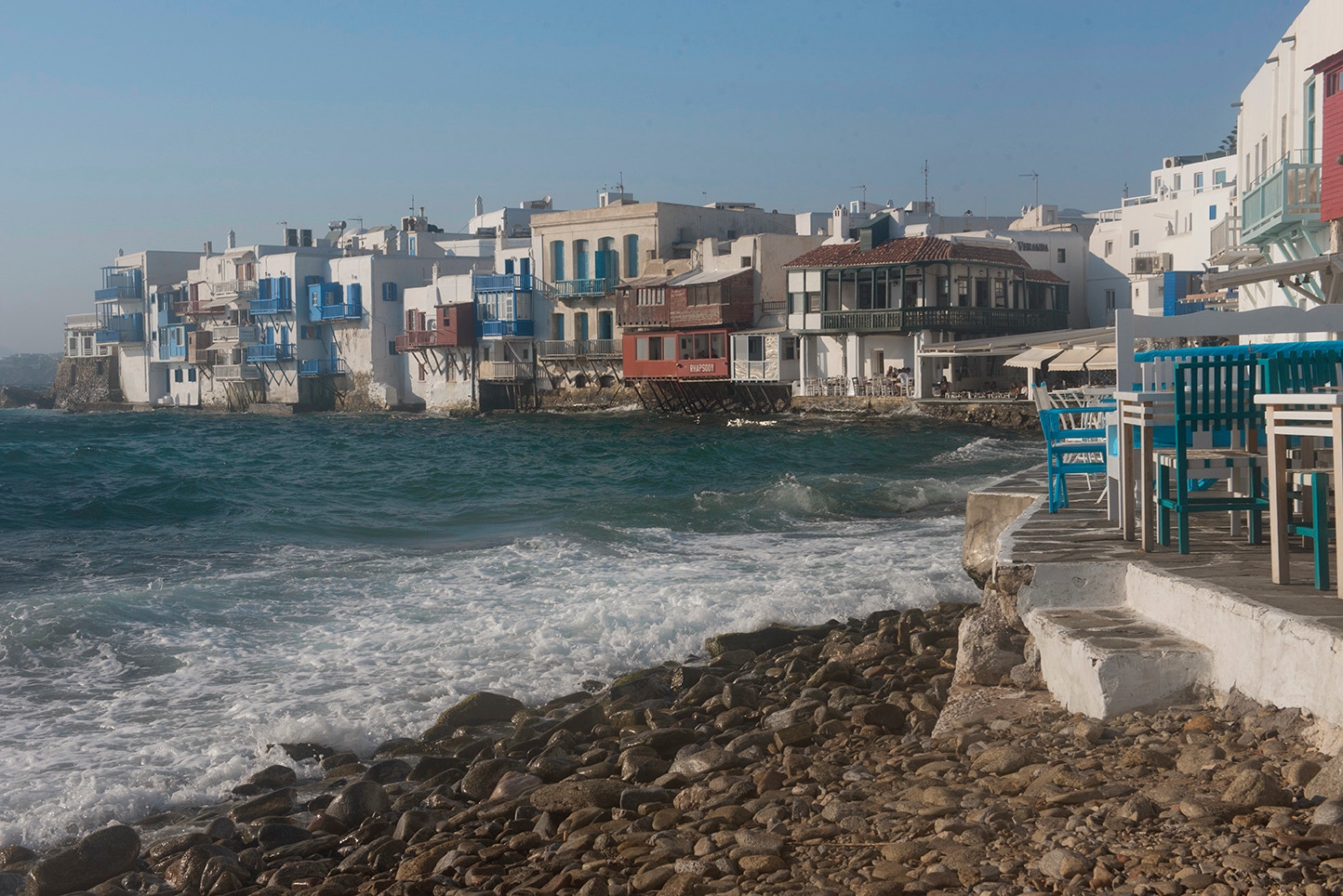 Mykonos Little Venice, waves crashing on rocky shore, colorful balconied houses