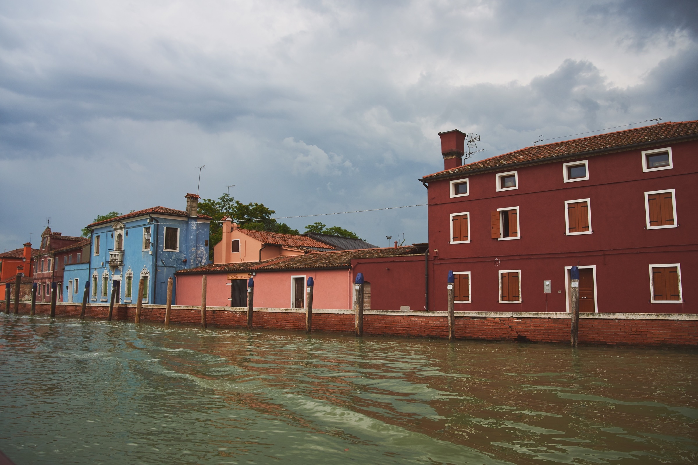 Burano colorful houses from the water, pink, blue, yellow facades