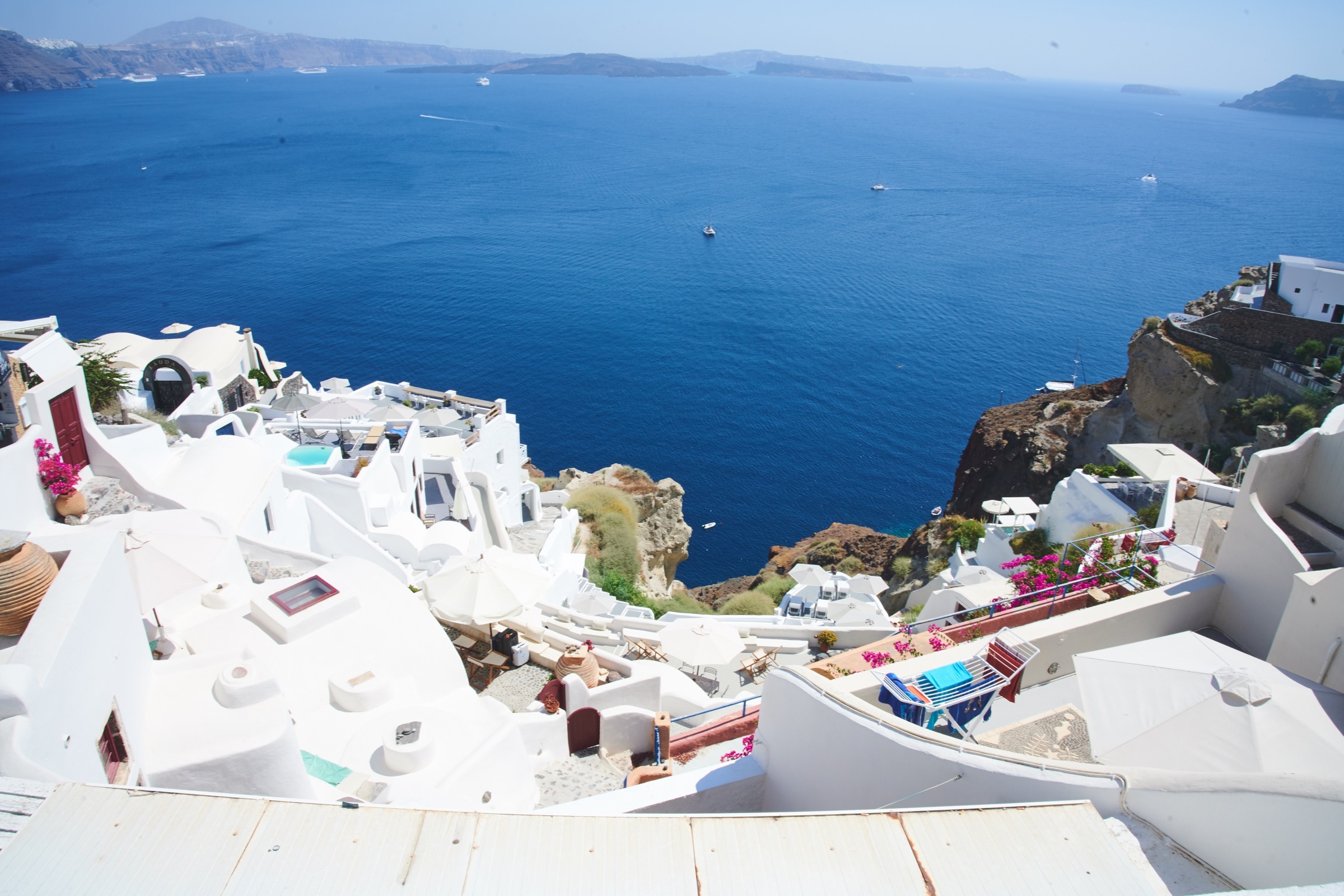 Santorini white rooftops and blue caldera, bougainvillea, classic Cycladic vista